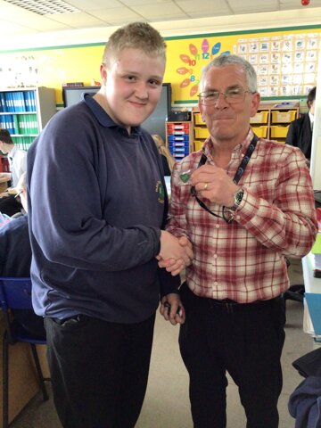 Image of Jamie receives his band badge from Mr Bradford